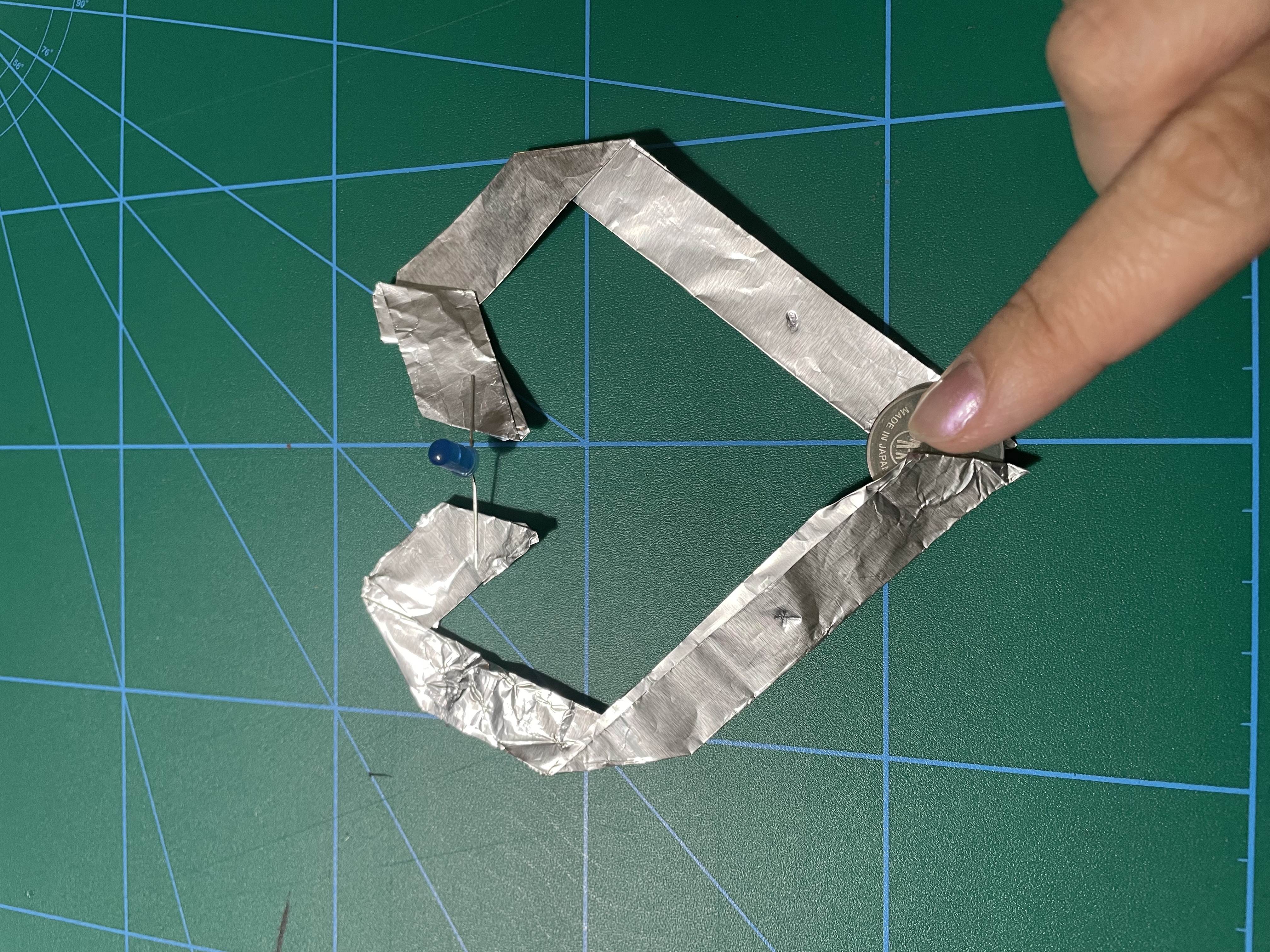 This is a simple circuit using aluminium foil in the shape of a heart. The top includes the light, whereas the bottom is where the battery connection is placed.